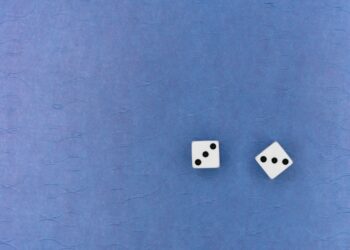 white and black dice on blue textile