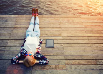 Woman relaxing upon a wooden jetty