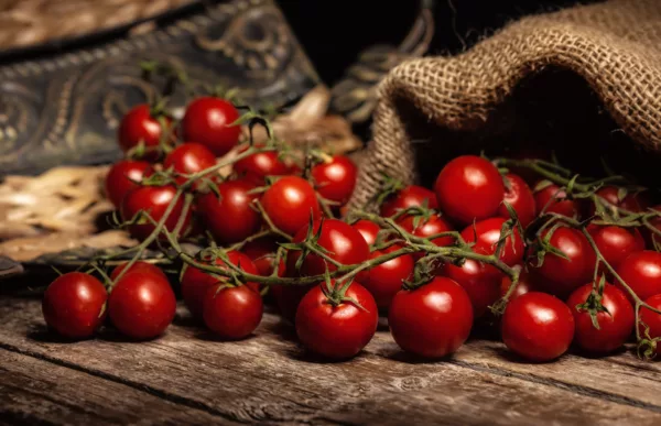 Still life of cherry tomatoes on wooden table.
